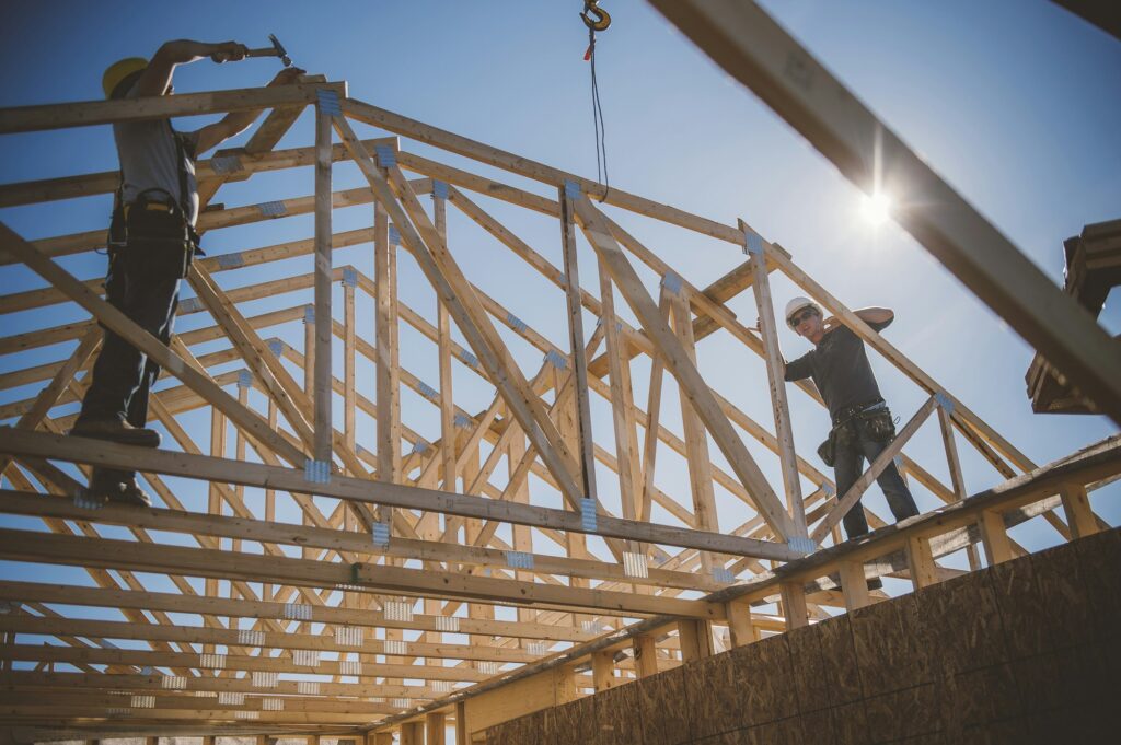 Builders working on rooftop frame of building