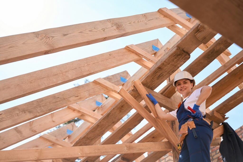 Confident woman builder checking quality of wooden roof construction