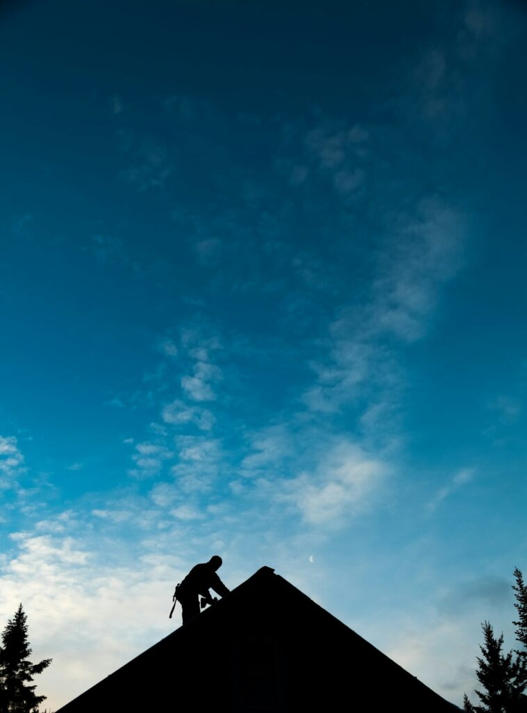 Contractor in Silhouette working on a Roof Top